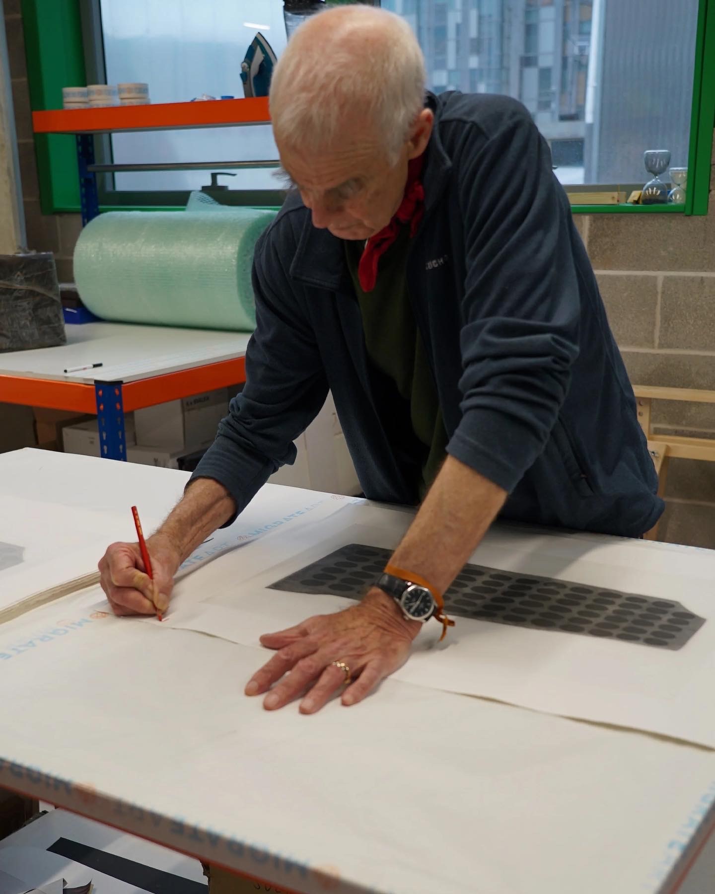Richard Long signing “WAR PAINT ON SLATE”, 2023, photopolymer etching on Double Imperial Somerset Satin. Image courtesy the artist and Migrate Art.